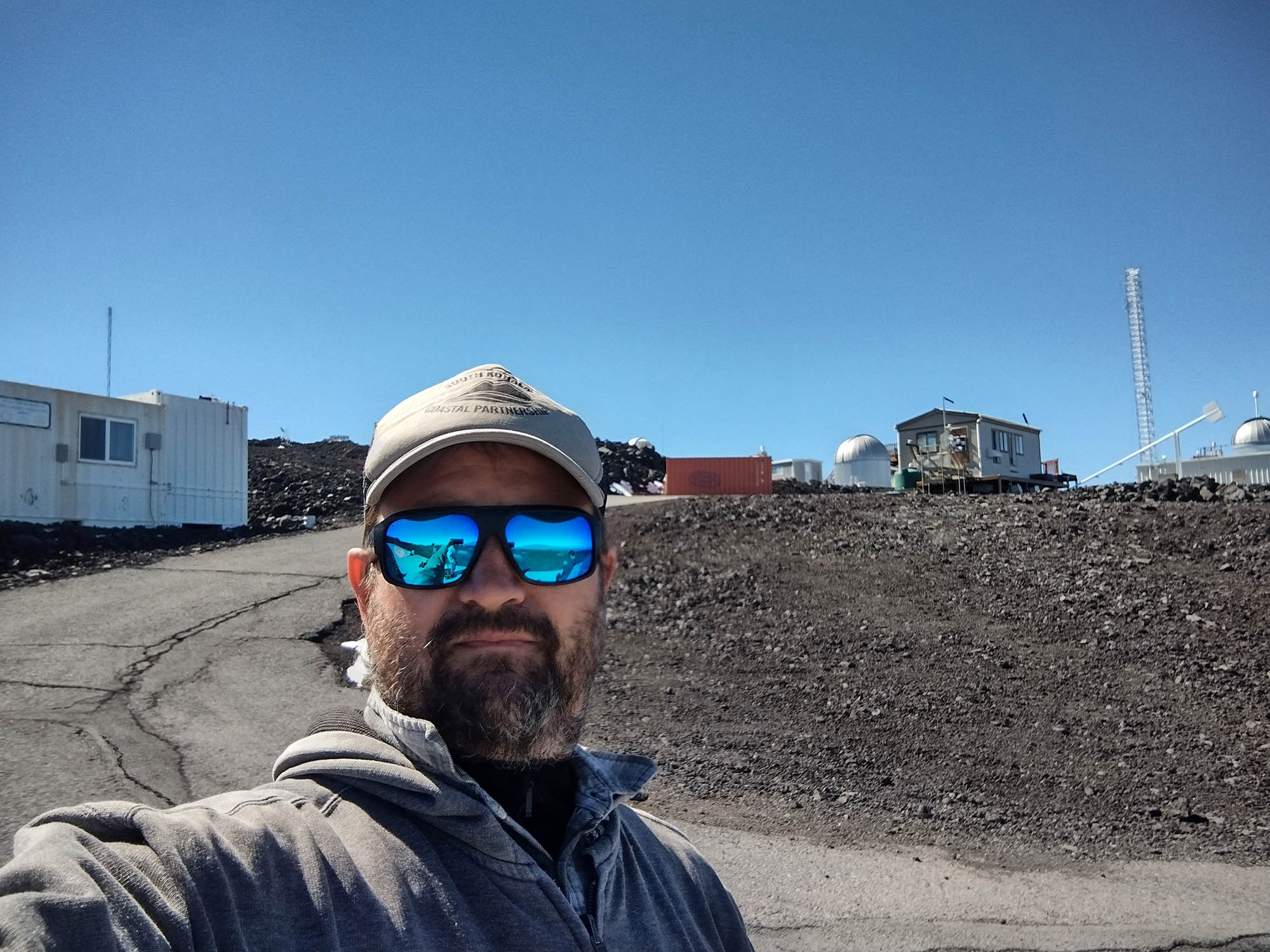 Ben Berkey at the Mauna Loa Observatory site with NOAA and GONG facilities in the background
