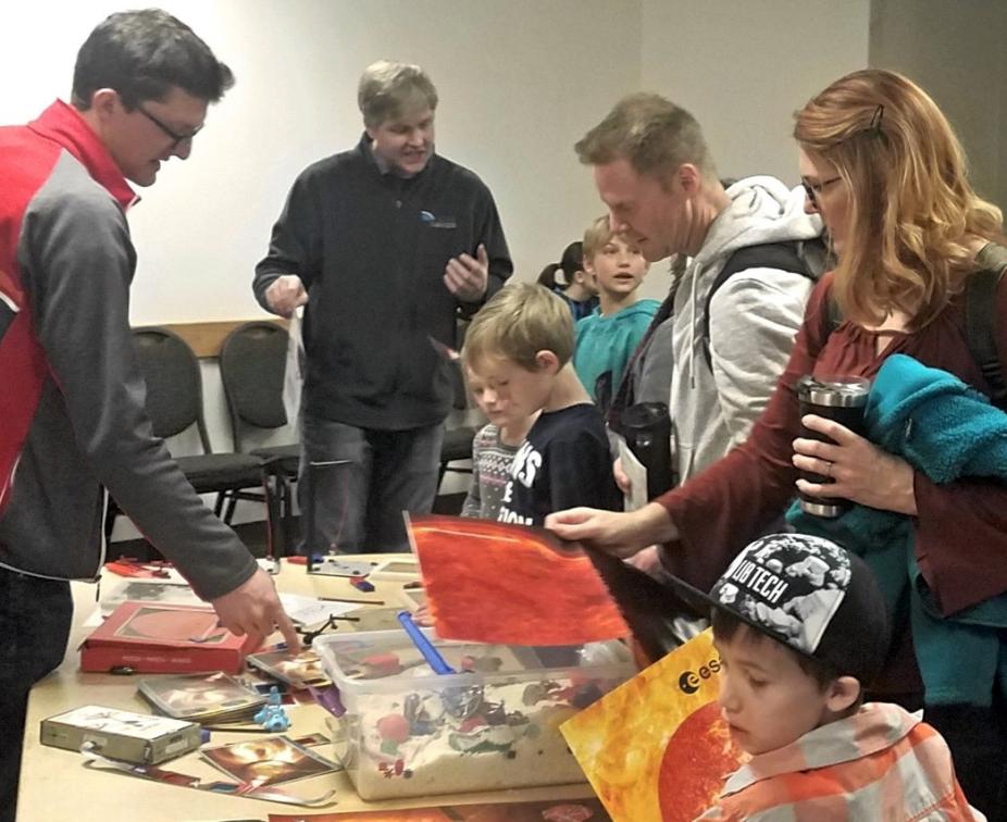Andrew Carlile (left) instructing children at 2020 Little Shop of Physics with hands-on activities (Ricky Egeland in background)