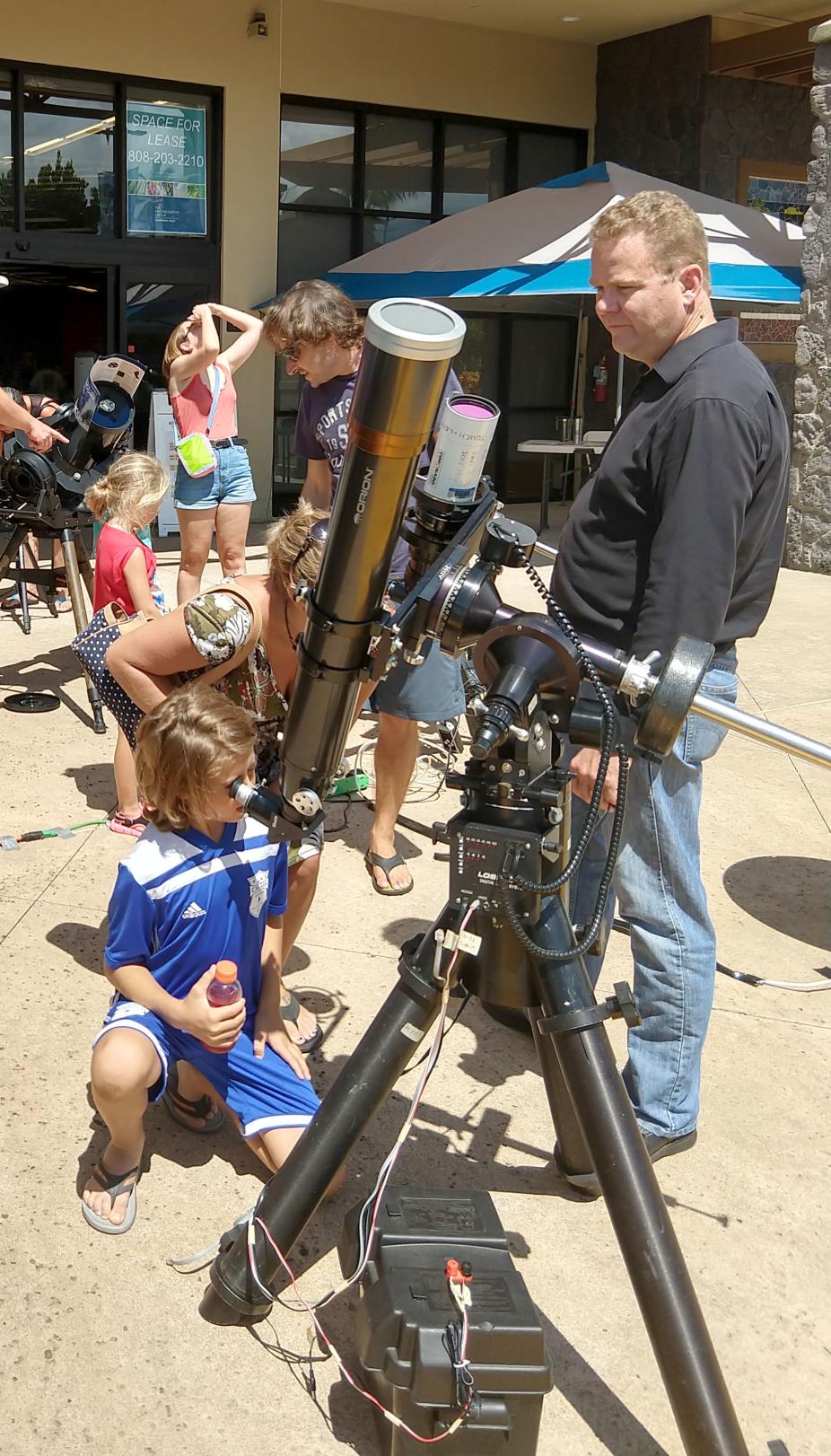 Child safely viewing the sun through optical telescope