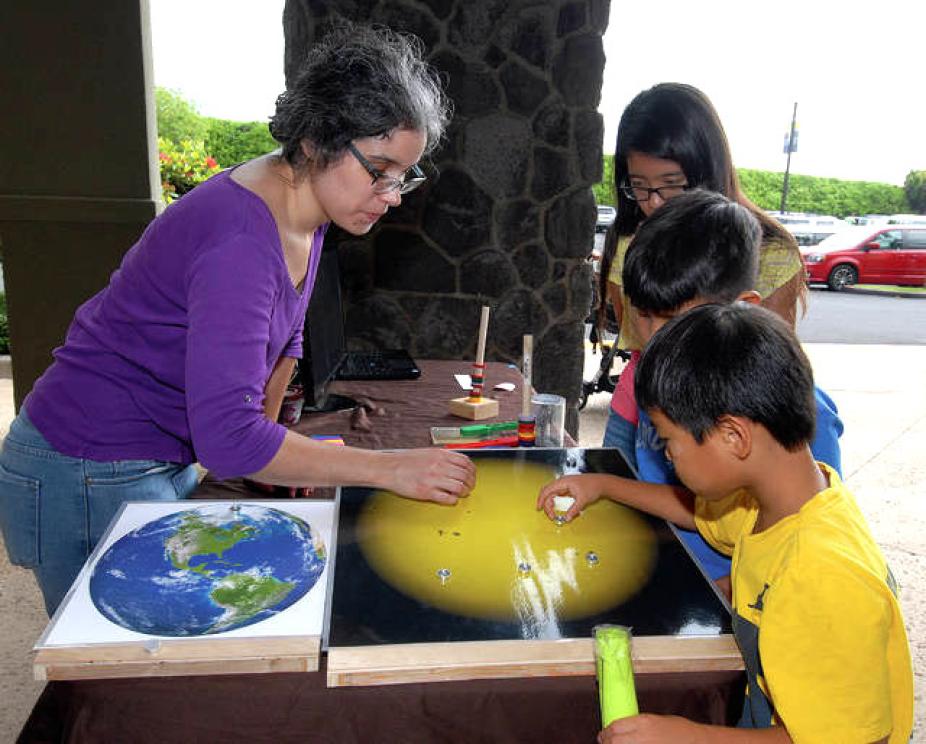 Lisa Waters demonstrating magnetic fields and effects on the sun at the local astronomy community event, Astroday in West Hawaii