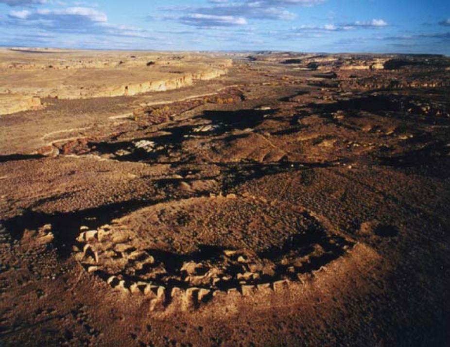 Aerial view of Chaco Canyon at sunset, looking approximately East. The circular structure in the foreground is the unexcavated ruin of Peñasco Blanco, the westernmost large dwelling in Chaco Canyon