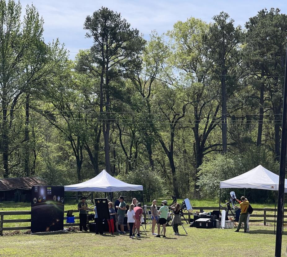 Eclipse booth offering telescope and binoculars to the public