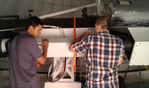 Electrical engineer, Brandon Larson, and Technician Rob Graves install the K-cor center section onto the solar spar at the NCAR Mesa Lab in Boulder
