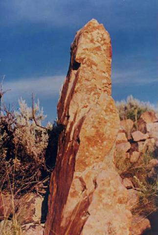 The flat, straight and elongated upper edge of this rock monolith is aligned approximately towards the North-East, and in the weeks preceding and following summer solstice would have cast a sharply pointed shadow on the outer wall of a building located immediately West of the monolith