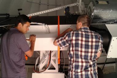 Electrical engineer, Brandon Larson, and Technician Rob Graves install the K-cor center section onto the solar spar at the NCAR Mesa Lab in Boulder